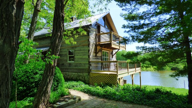 A log cabin with a deck and a view of a lake. - Beautiful, 200 year old Log home - Secluded, 30 Min. from Downtown (Indianapolis, Acton)