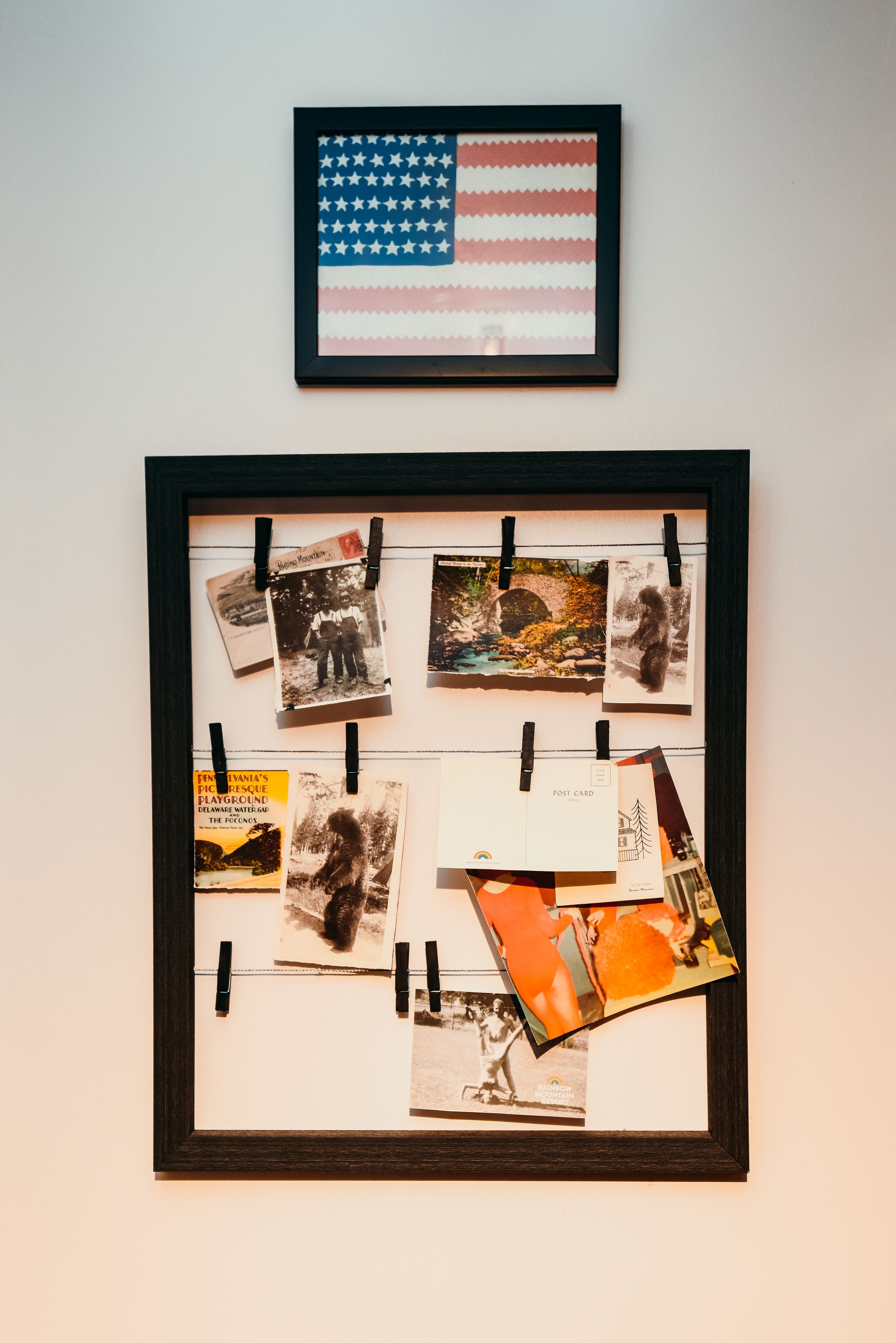 Un collage de photographies et de cartes postales encadré, accroché au mur.
