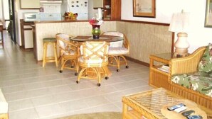 A compact living space with a dining area, kitchen, and a seating area with a coffee table. - Beachfront//Oceanfront//Ocean View - 1/2/3 Bedroom Kihei Condo (Kihei)