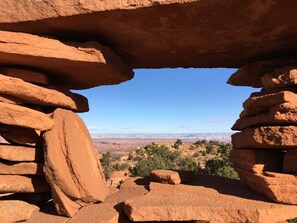 A natural rock formation with a clear view of a distant landscape.