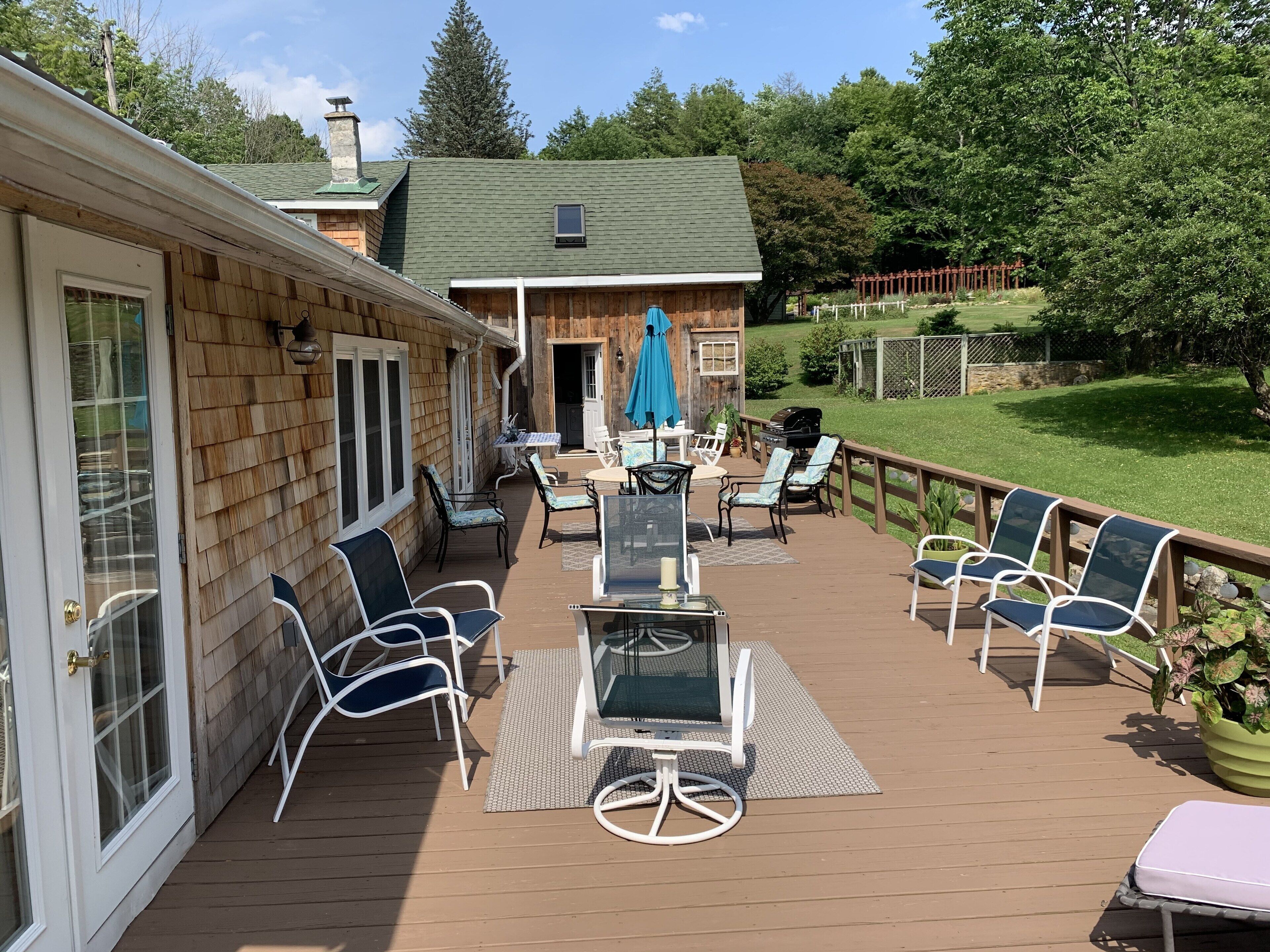 A deck with outdoor furniture, a barbecue grill, and a covered patio area.