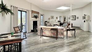 Un amplio salón con techo alto, chimenea y mesa de comedor.