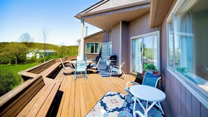 Una terraza con mobiliario exterior, una parrilla y vistas del paisaje circundante.