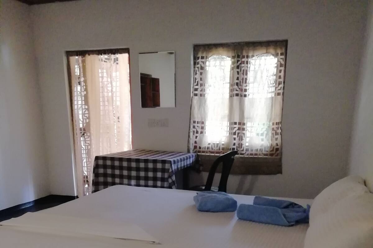 Ein Zimmer mit einem Bett, einem Tisch und einem Stuhl.