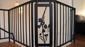 A black metal staircase with a floral design on the handrail.