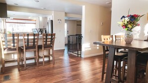 A spacious kitchen with wooden cabinets and a dining area with a wooden table and chairs.