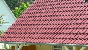 A covered patio area with a red-tiled roof, a table with chairs, and a wooden door. - Apartment 12 - apartment / apartment in Binz (Binz)