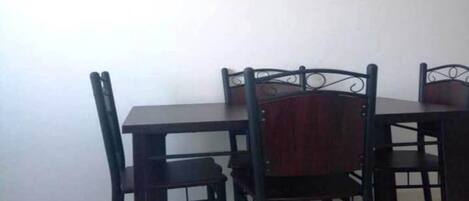 A dining area with a wooden table and chairs.
