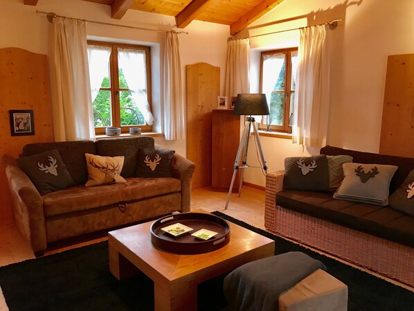 A cozy living room with two sofas, a coffee table, and a floor lamp.