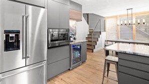 A modern kitchen with stainless steel appliances, a built-in oven, and a coffee machine. - Luxury Mountainside Retreat at Silver Star — 3 King En-Suites (Park City)