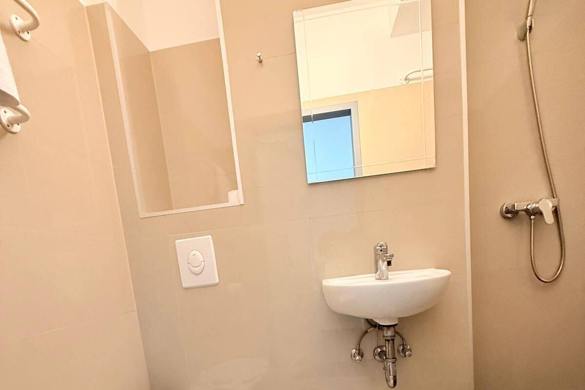 A modern bathroom with a toilet, sink, and shower.