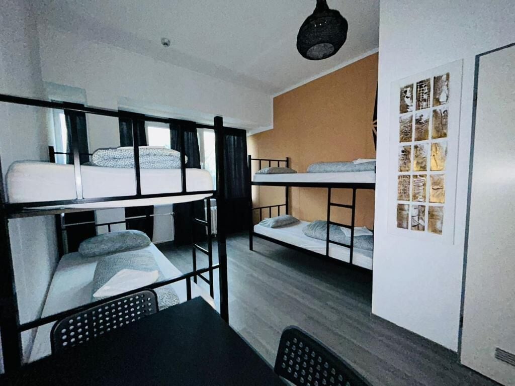 Un dormitorio con literas, un escritorio y una silla.