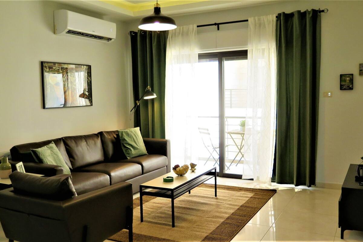 A living room with a sofa, coffee table, and a television.