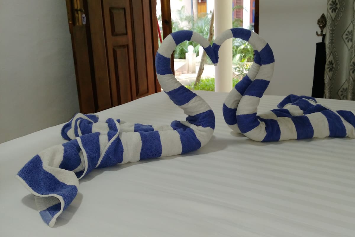 Een bed met een blauw-wit gestreepte handdoek, gerangschikt in een slangvormig patroon.