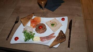 Un plato de comida con una copa de vino sobre una mesa de madera.