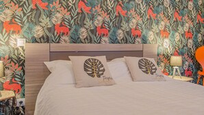 Quarto com uma cama, duas mesas de cabeceira, um abajur e uma cadeira.