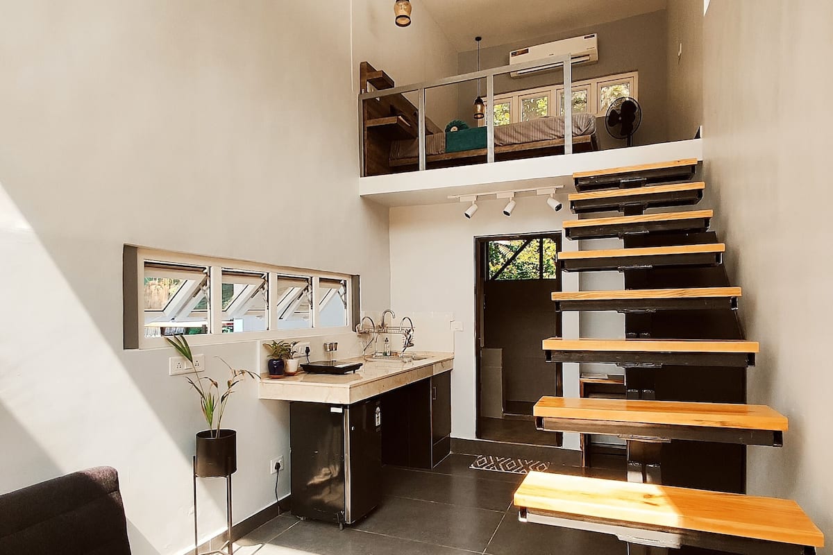 A modern interior with a staircase, a dining area, and a kitchen.