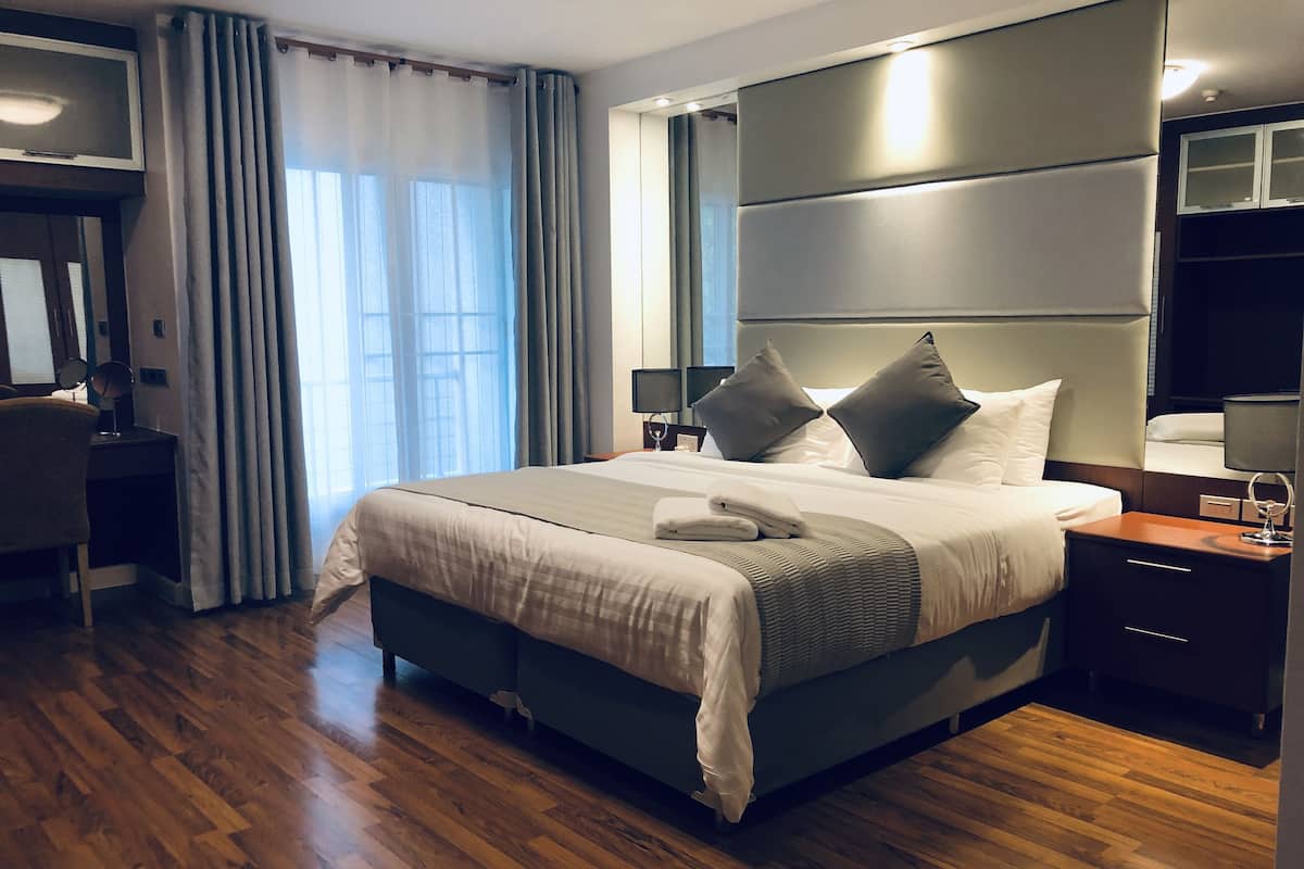 Una habitación de hotel moderna con una cama grande, un escritorio y una televisión.