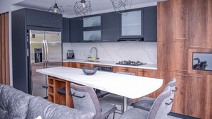 A modern kitchen with a central island, stainless steel appliances, and wooden cabinets. - 3 BEDROOM PENTHOUSE MIDDLE OF PARK LLERAS PRIVATE ROOF TOP WITH HOT TUB AC (Medellin)