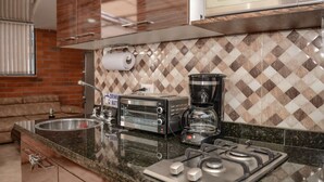 A kitchen with a gas stove, a coffee maker, a toaster, and a sink. - Lower Penthouse Two Bedroom AC DECK with Hot Tub Elevator AC (medellin)