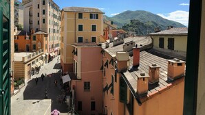 Un vicolo stretto fiancheggiato da edifici, cielo sereno e una montagna sullo sfondo.
