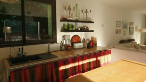 A kitchen with a window, a sink, a countertop, and a dining area with a table.