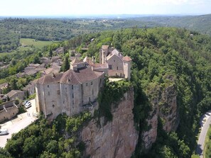 Un castillo medieval enclavado en un acantilado con vistas a un valle.