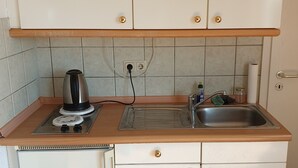 Uma cozinha compacta com fogão embutido, pia e bancada.