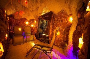 Un interior que recuerda a una cueva, con chimenea, un estandarte que dice "Alka" y disposición de asientos.