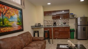 A modern kitchen with wooden cabinets, a stainless steel refrigerator, and a coffee maker. - King One bedroom AC Hot tub elevator (Medellin)