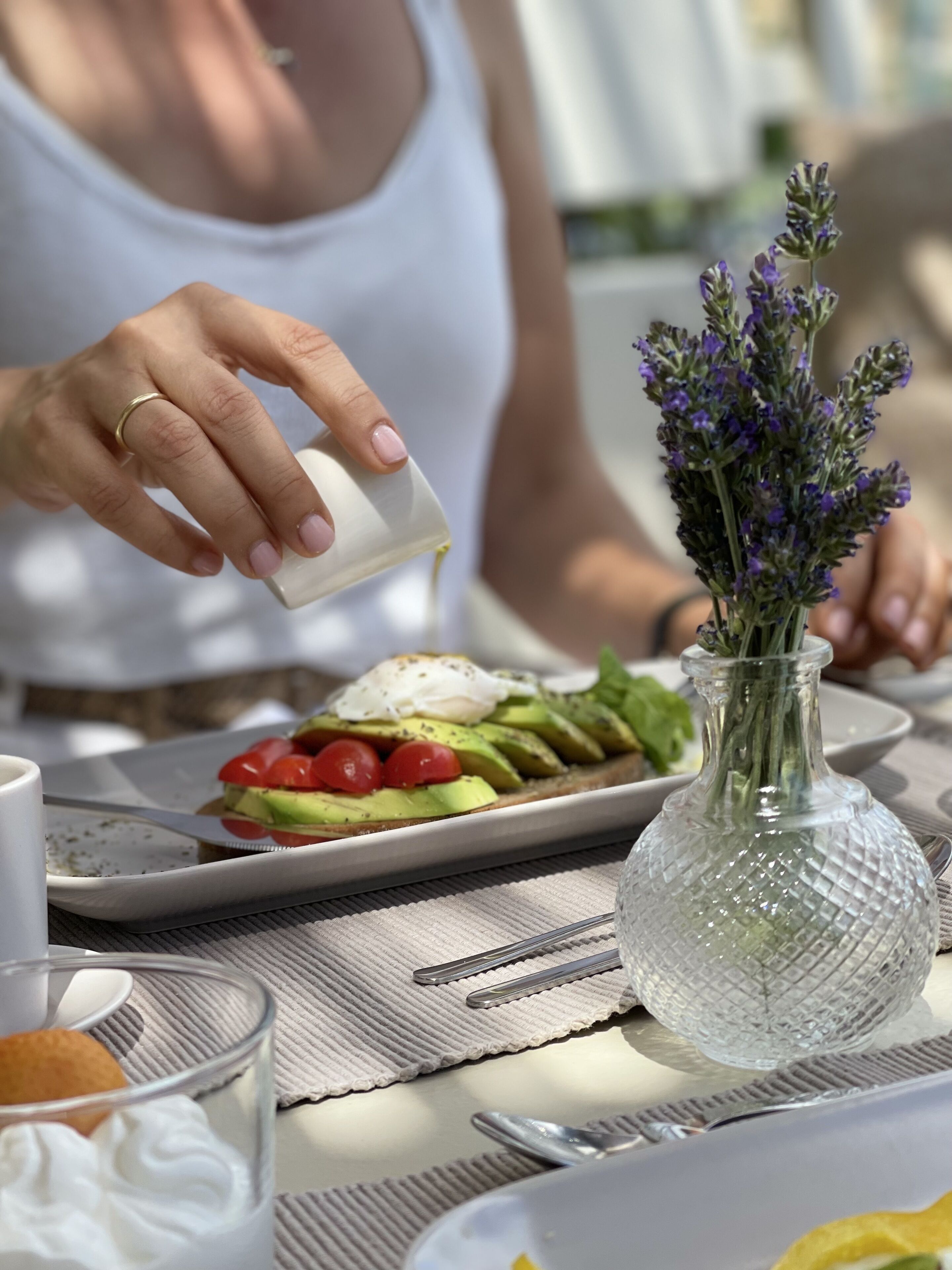 A person pouring a white substance onto a plate of food.