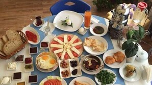 A breakfast table with various dishes, including eggs, toast, and pastries. - Sir Motel (Edremit)