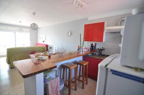 A kitchen with a wooden island, red cabinets, and a white refrigerator.