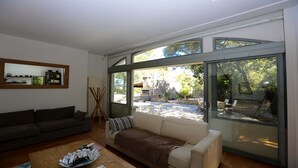 A living room with a sofa, a coffee table with magazines, and a painting on the wall. - House with character beetween Nimes (15km) and MontpellierHouse with character (Boissières)