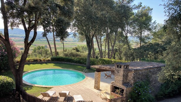 A pool area with a stone deck, lounge chairs, and a stone fireplace. - House with character beetween Nimes (15km) and MontpellierHouse with character (Boissières)