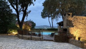 A stone patio with a pool, surrounded by trees and a stone wall. - House with character beetween Nimes (15km) and MontpellierHouse with character (Boissières)