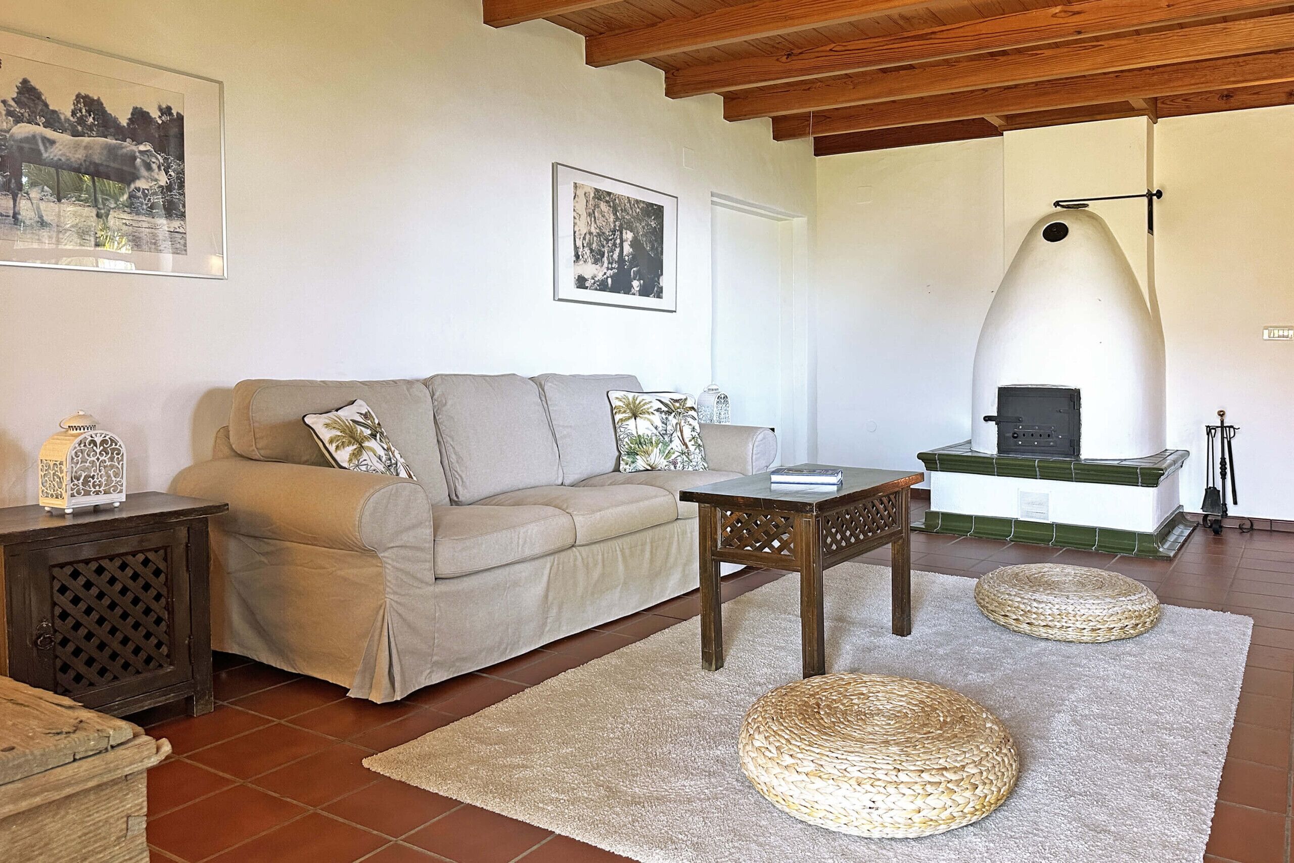 Una sala de estar con sofá, mesa de centro, chimenea y alfombra de fibras naturales.