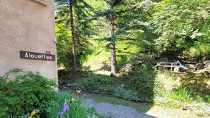 A building labeled "Alouettes" with a gravel path leading to a wooded area.