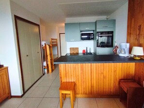 A compact kitchen with a wooden island, a built-in oven, and a coffee maker.