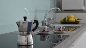 A kitchen with a coffee maker, a sink, and a fruit bowl. - CdApartments - 2-Min Walk to the Beach & Town Center (Minori)