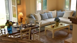 Un salon chaleureux avec un canapé, une table basse et une table à manger, le tout disposé pour un repas.