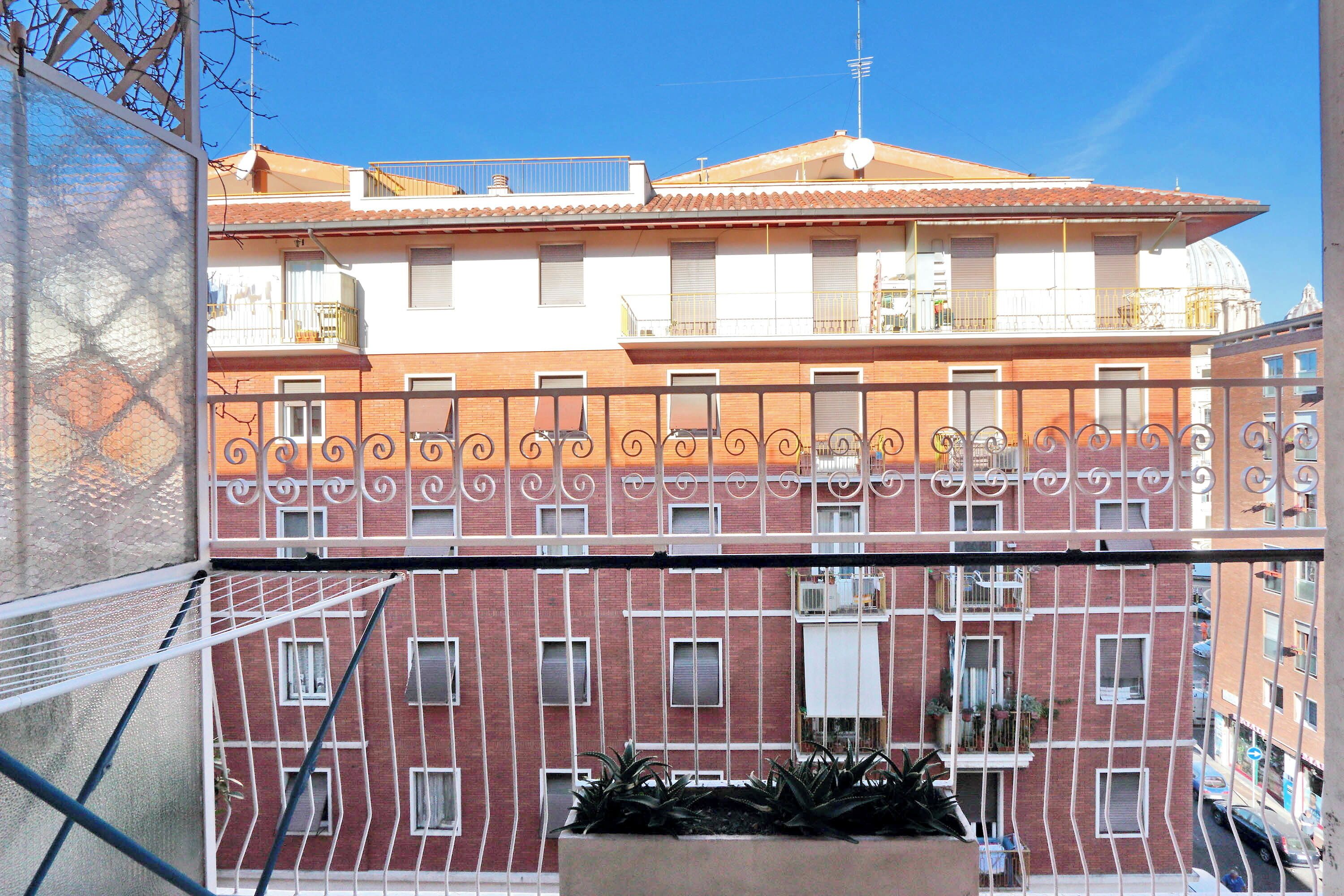 A multi-story building with balconies and a clear sky.