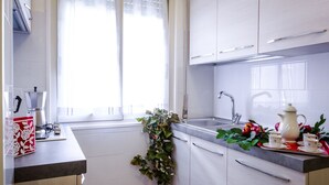 A modern kitchen with white cabinets, a sink, and a window with curtains. - LOVELY APARTMENT CENTER ROME 100M FROM VATICAN INTERNET FREE WI-FI (Roma)