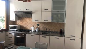 Una cocina moderna con armarios blancos, microondas, estufa y lavaplatos.
