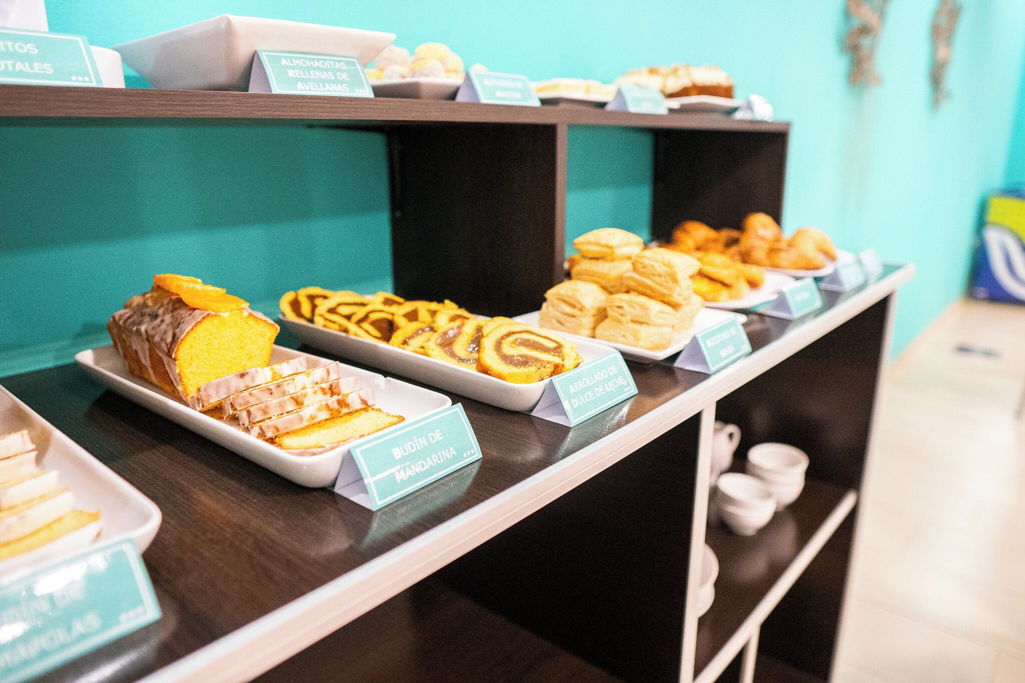 A buffet with various pastries and desserts, including a cake labeled 'BUOIN DE MANDARINA'.