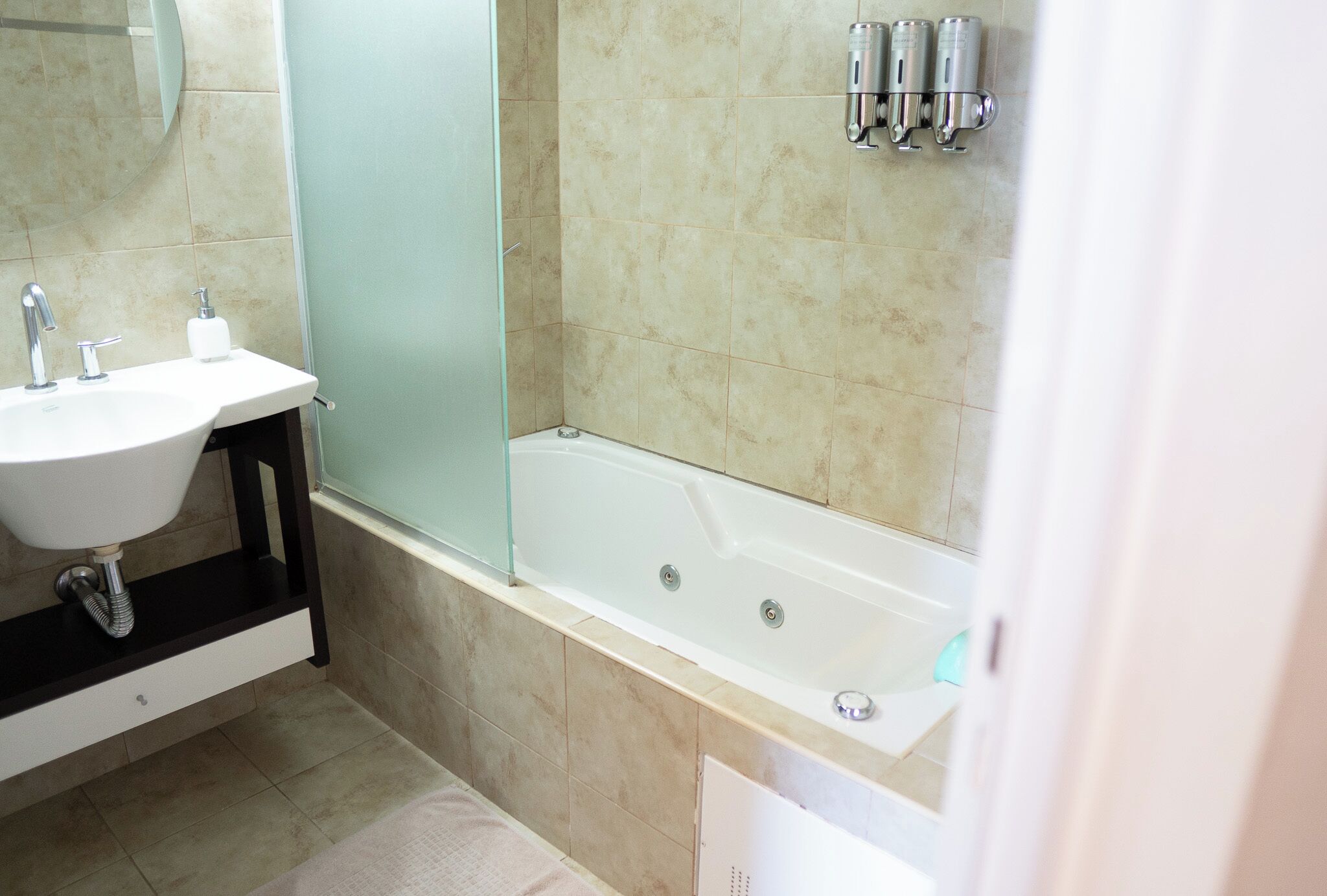 Ein Badezimmer mit Waschbecken, Spiegel und Badewanne.