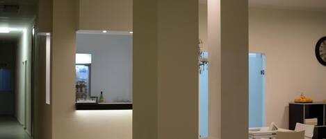 A modern interior with a kitchen area, dining space, and a visible clock on the wall.