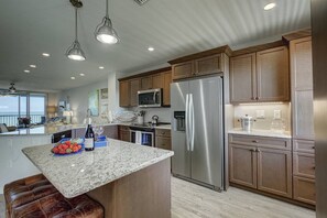 A modern kitchen with granite countertops, stainless steel appliances, and wooden cabinetry.