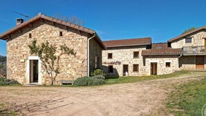 Un edificio de piedra con una puerta, ventanas y un pequeño balcón.