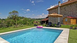A swimming pool with a stone house in the background.